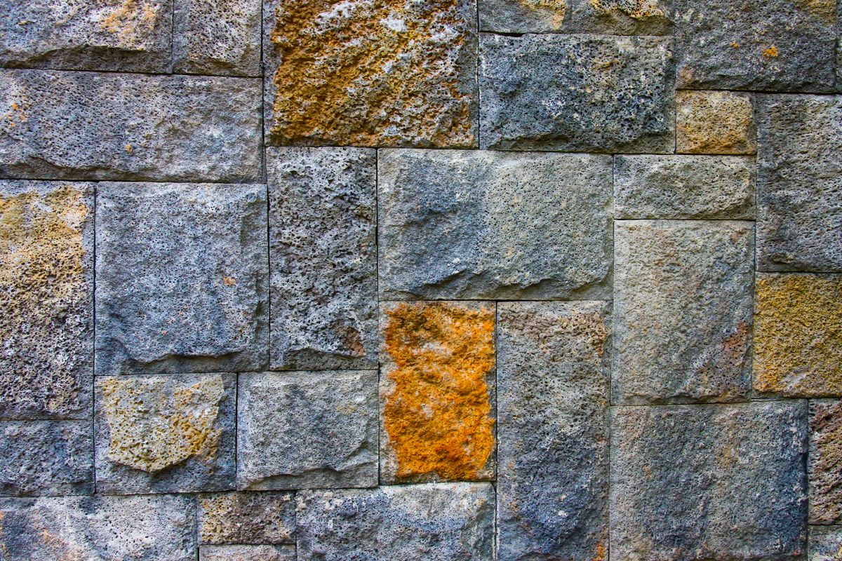 Close-up of textured stone facing in gray and warm earth tones.
