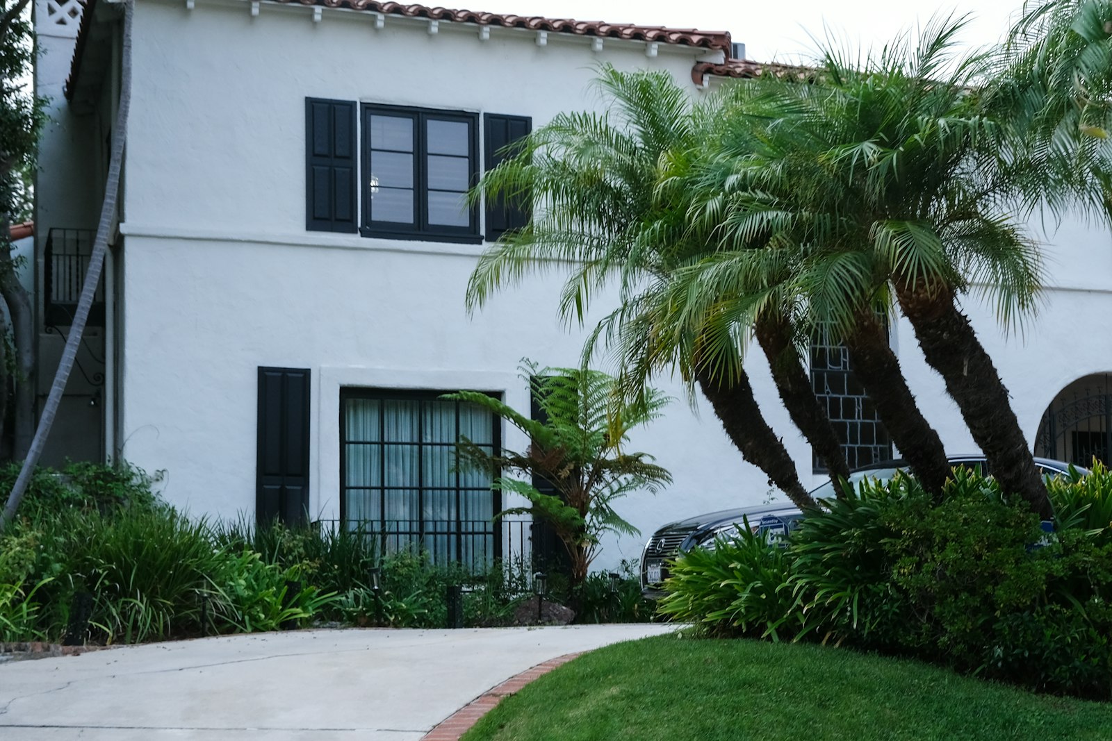 Finished white stucco home with dark-framed windows.