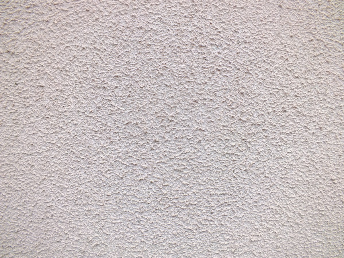 Close-up of a light-colored textured plaster finish.